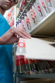 Woman with file in hospital archives