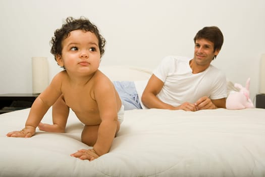 Baby and father on bed