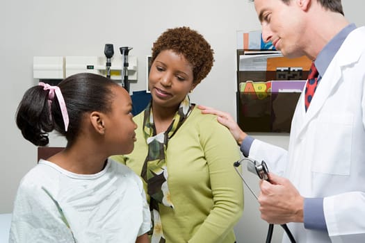 Doctor reassuring mother and daughter