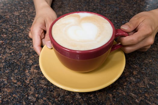 Person holding cappuccino