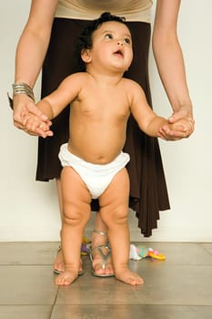 Mother helping baby to walk
