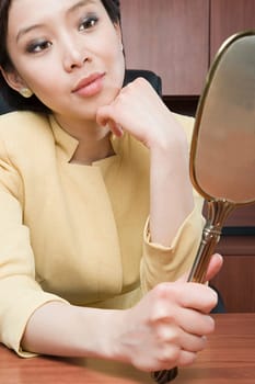 Businesswoman looking at mirror