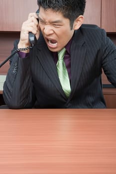 Businessman shouting down phone