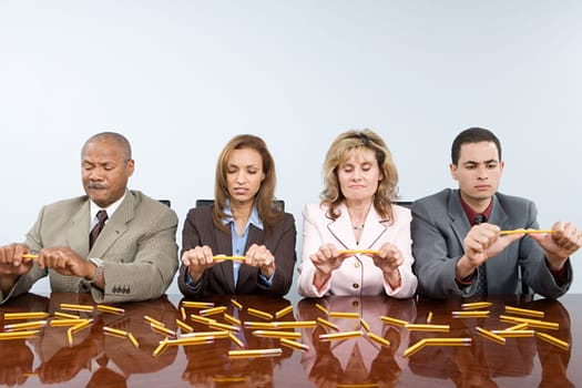 Businesspeople breaking pencils