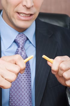 Businessman breaking pencil