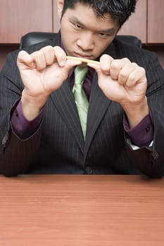 Businessman breaking pencil