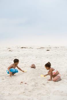 Children burying father in sand