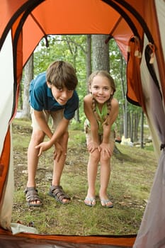 Boy and girl looking into tent