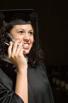 Female graduate using a cellular phone