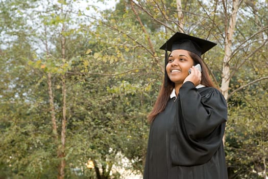 Female graduate using a cellular phone