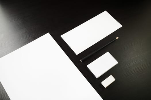 Blank corporate identity template on black wooden table background. Photo of blank stationery. Mock up for design portfolios.