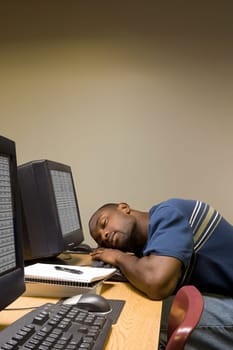 Male student sleeping at his computer