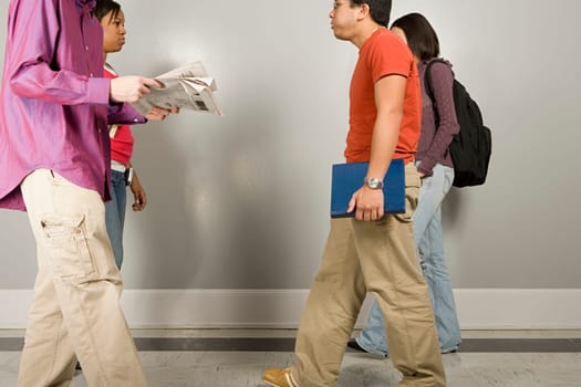Four students walking along corridor