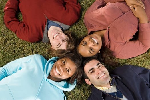 Four students lying down outdoors