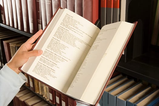 Female student reading a book in the library