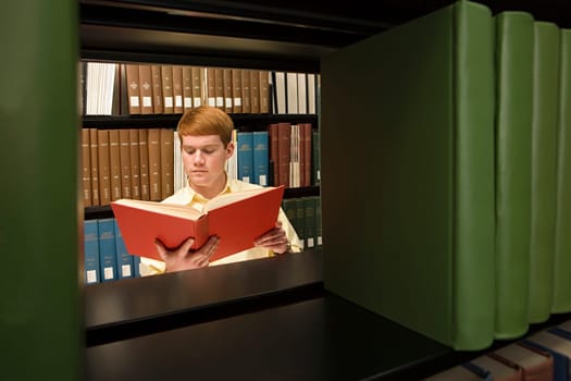 Male student reading in the library