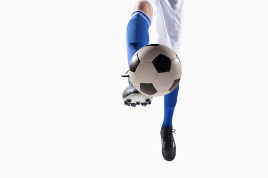 Athlete kicking soccer ball