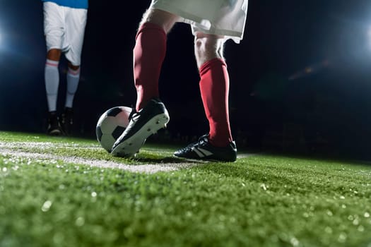 Two soccer players kicking a soccer ball