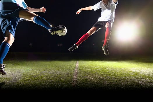 Two soccer players kicking a soccer ball