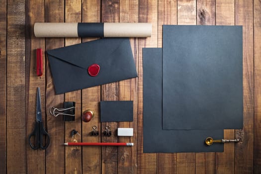 Photo of blank stationery set on wood background. Black corporate identity template for placing your design. Responsive design mockup. Top view.
