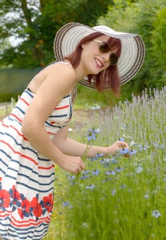 portrait of pretty girl wearing hat, dress and sunglasses. She smiling to the camera.