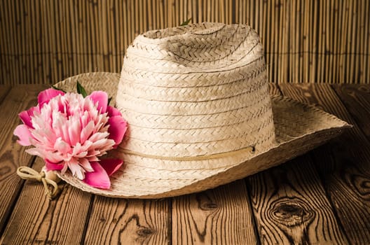 Straw hat and peony flower, close-up