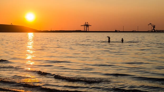 Couple bathing at sunset in the sea