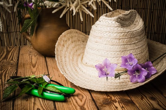Straw hat and flowering campanula, close-up