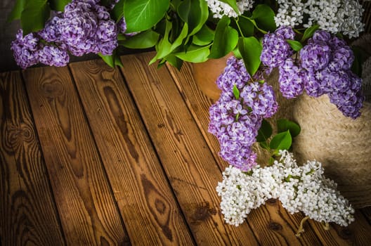 Still-life with a bouquet of lilacs and a straw hat, close-up