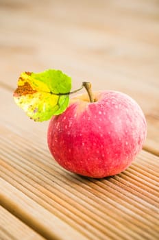 Ripe red apple with a leaf on a blackboard, close-up