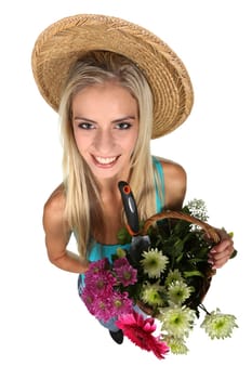 Beautiful young lady with a basket of colorful flowers