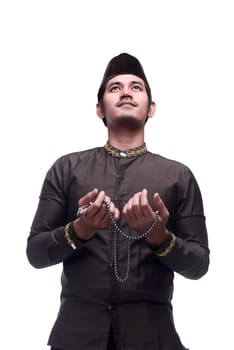 Young asian muslim man praying with prayer beads isolated over white background