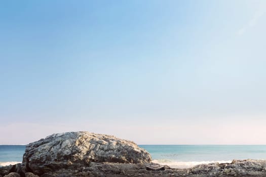 Giant rock and sea waves with blue sky at sunny day