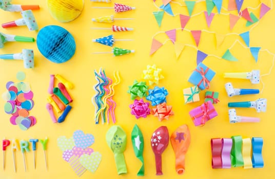 Froehliches buntes Party Zubehoer on yellow background