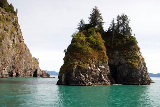 Beautiful rock buttes jut out of the ocean growing vegetation