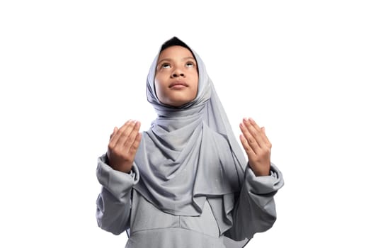 Little asian muslim girl praying to god isolated over white background