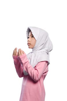 Asian muslim girl wearing veil and praying to god isolated over white background