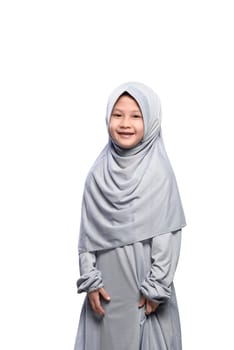 Little asian muslim girl in veil with smile standing isolated over white background