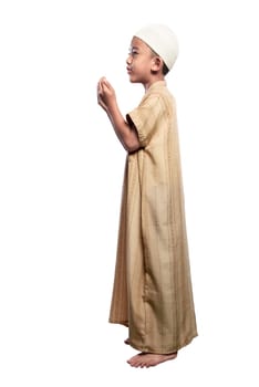 Little asian muslim kid in traditional dress with cap praying isolated over white background