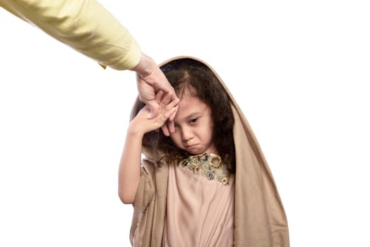 Asian muslim child kissing a hand of her parents as respect isolated over white background