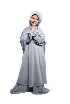 Little asian muslim girl wearing hijab praying isolated over white background