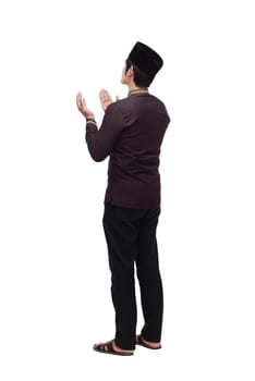 Back view asian muslim man raising hand and praying isolated over white background