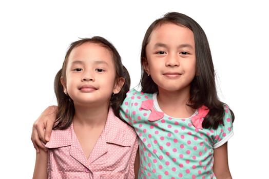 Happy two asian little girl hugging and having fun isolated over white background