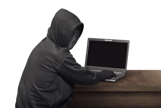 Portrait of hacker man with mask looking back while typing laptop on desk isolated over white background