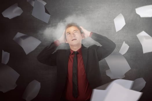 Worried asian businessman full with flying papers being overloaded in the black background