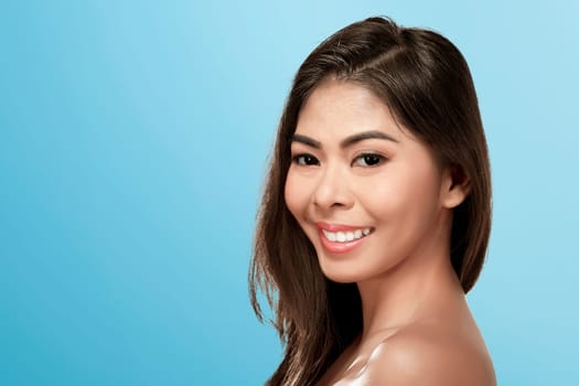 Beautiful asian woman face with natural skin over blue background
