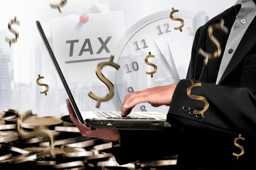 Businessman holding laptop with deadline for Tax payment on modern background