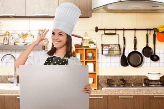 Happy asian female chef with ok gesture holding white board for copyspace over restaurant kitchen background