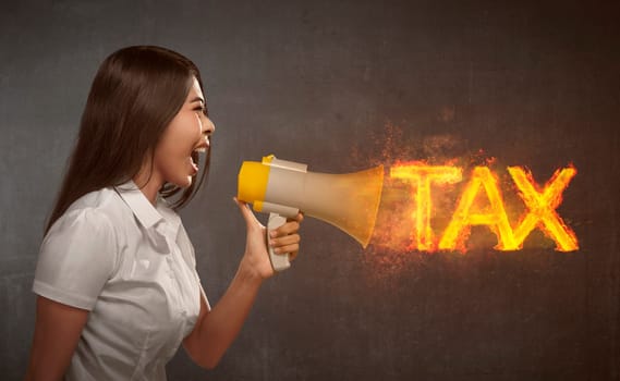 Asian business woman holding megaphone with TAX  announcement on the wall