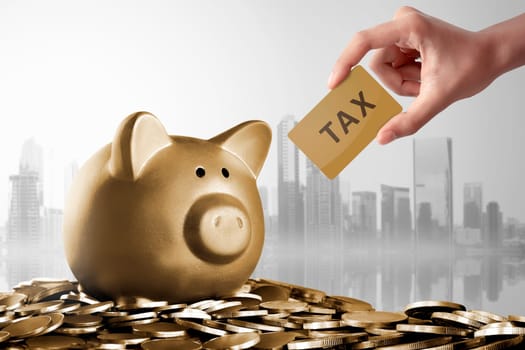 Piggy bank with Tax card sign over gold coin background